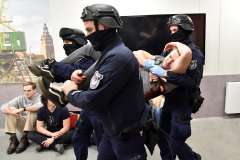 funkcjonariusze policji niosący na rękach mężczyznę