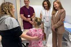 Trzy kobiety, mężczyzna i dziewczynka rozmawiają w sali szpitalnej