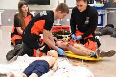 ratownicy medyczni ratujący ranne osoby leżące na podłodze