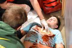 ratownicy medyczni ratujący ranne osoby leżące na podłodze