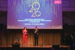 Dwie osoby stoją na scenie przed dużym ekranem z napisem „2026 Spotkanie Noworoczne Pomorskiego Uniwersytetu Medycznego w Szczecinie