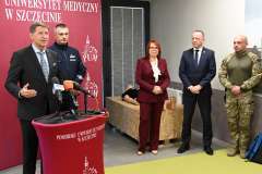 Prezentacja dla mediów – pięć osób stoi przy mównicy z mikrofonami.