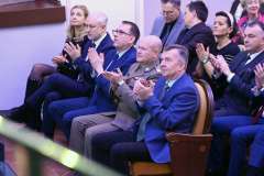 Publiczność siedząca na widowni bije brawo podczas uroczystego wydarzenia