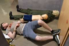 ranne osoby leżące na podłodze, jeden mężczyzna, dwa manekiny