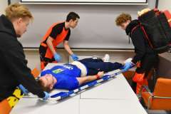 ratownicy medyczni ratujący ranną osobę leżącą na noszach na stole