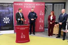 Przemówienie przy mównicy PUM z udziałem policjantów i przedstawicieli uczelni
