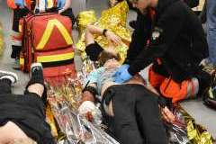 ratownicy medyczni ratujący ranne osoby leżące na podłodze