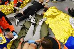 ratownicy medyczni ratujący ranne osoby leżące na podłodze