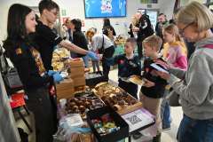 Dzieci wybierają ciastka przy stoisku z wypiekami