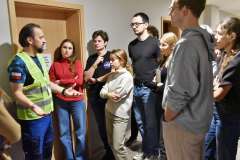 rozmawiające osoby stojące na korytarzu