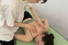 W sali warsztatowej dwie kobiety podczas pokazu masażu