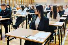 młodzi ludzie siedzący w ławkach