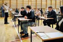 młodzi ludzie siedzący w ławkach