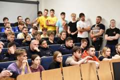 młode kobiety i młodzi mężczyźni siedzący na sali audytoryjnej