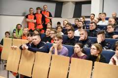 młode kobiety i młodzi mężczyźni siedzący na sali audytoryjnej