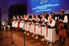 espół w strojach ludowych stoi na scenie pod ekranem z napisem 2026 podczas Spotkania Noworocznego Pomorskiego Uniwersytetu Medycznego