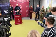 Konferencja prasowa w PUM, wystąpienie i zgromadzeni uczestnicy. Widać kamery i dziennikarzy