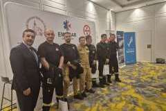 kilku mężczyzn stojących na tle ścianki promującej konferencję