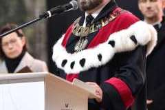 Mężczyzna w todze przemawia przy mównicy