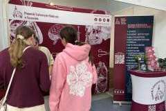 młodzież podczas rozmowy przy stoisku promocyjnym uczelni