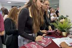 młodzież podczas rozmowy przy stoisku promocyjnym uczelni