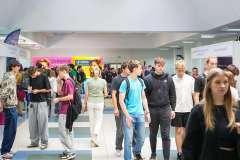 grupa młodych ludzi chodzących po korytarzu