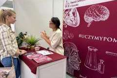 młodzież podczas rozmowy przy stoisku promocyjnym uczelni