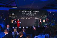 Scena XXIV Gali Biznesu w Szczecinie z informacją o wyróżnieniu w kategorii Osobowość Nauki; prowadzący stoją na scenie