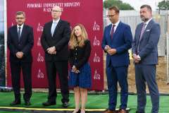 grupa osób stojących na tle ścianki z logotypami