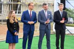 grupa osób stojących przed terenem budowy