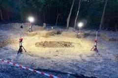 oświetlone miejsce prac ekshumacyjnych