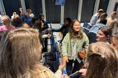 grupa młodych osób stojących w sali wykładowej 