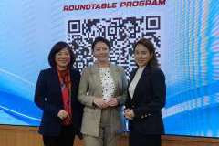 trzy kobiety stoją na tle ekranu rzutnika