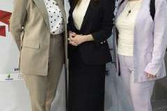 trzy kobiety stojące przed ścianką z logotyami