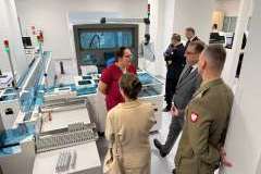 Grupa dorosłych osób stoi w pomieszczeniu i ogląda otoczenie