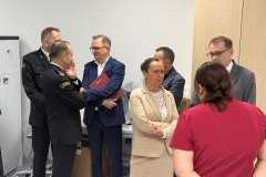 Grupa dorosłych osób stoi w pomieszczeniu i ogląda otoczenie