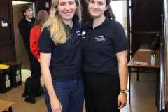 dwie młode kobiety stoją i uśmiechają się