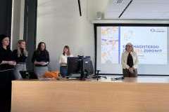 Pięć kobiet stoi w sali wykładowej przed ekranem z prezentacją