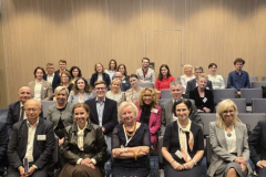 grupa osób siedząc na sali konferencyjnej podczas konferencji