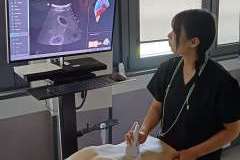 Młoda kobieta w ubraniu medycznym w sali warsztatowej robiąca USG na fantomie