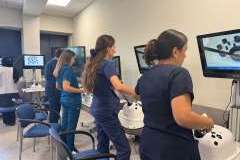 Młode osoby w ubraniach lekarskich ćwiczące umiejętności na laparoskopach