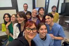 Grupa młodych, uśmiechniętych ludzi w sali warsztatowej.