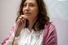 Kobieta trzyma mikrofon i przemawia przed wykładem