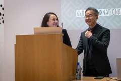 Mężczyzna i kobieta stoją przy mównicy, uśmiechają się i rozmawiają podczas spotkania naukowego