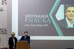 mężczyzna i kobieta stojący przy mównicy, w tle na ekranie slajd z wykładu