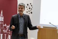 na scenie stoi mężczyzna, gestykuluje, w tle ścianka promocyjna PUM