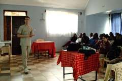 grupa ludzi siedzi w sali słuchając mężczyzny w uniformie medycznym