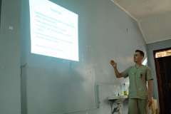 mężczyzna w uniformie medycznym w trakcie pokazywania prezentacji na ekranie