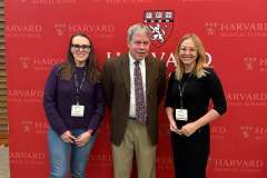 dwie kobiet i jeden mężczyzna stoją na tle ścianki promocyjnej