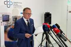 mężczyzna w okularach przemawia do mikrofonu